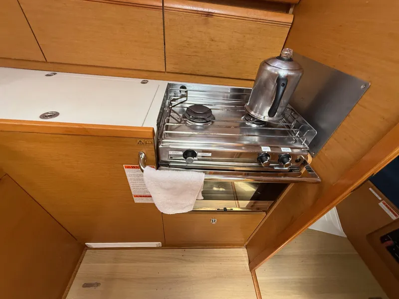 Slide: The Image of Compact kitchen area in a 2015 Jeanneau 409 sailboat with stove and kettle. - 23