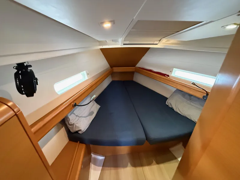 Slide: The Image of Cozy cabin interior of 2015 Jeanneau 409 sailboat with blue cushions and wooden finish. - 25