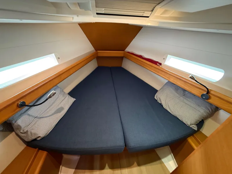 Slide: The Image of Cozy cabin interior of 2015 Jeanneau 409 sailboat with blue cushions and striped pillows. - 26