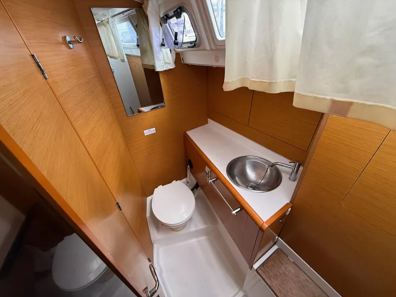 Slide: The Image of 2015 Jeanneau 409 yacht bathroom with wooden cabinetry, sink, and toilet. - 29