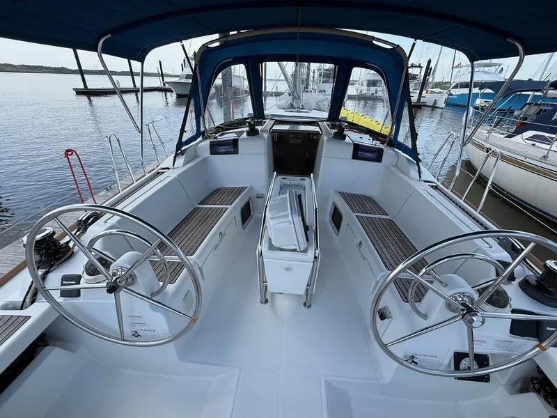 Slide: The Image of Cockpit of 2015 Jeanneau 409 sailboat with dual steering wheels and blue canopy. - 4
