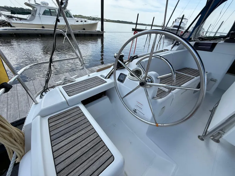 Slide: The Image of Cockpit of 2015 Jeanneau 409 sailboat with steering wheel and seating, docked at marina. - 5