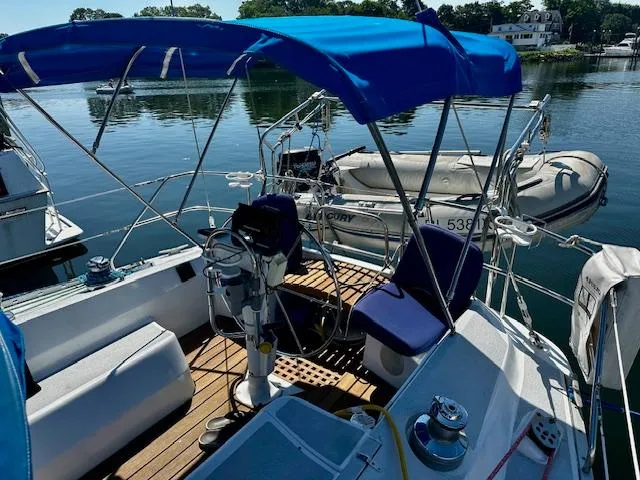 Slide: The Image of 1986 Hunter Legend 45 sailboat cockpit with blue canopy and docked dinghy. - 14