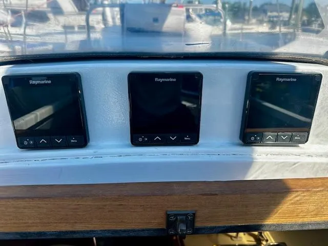 Slide: The Image of Three Raymarine displays on a 1986 Hunter Legend 45 yacht dashboard. - 15