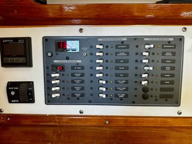 Slide: The Image of Control panel of a 1986 Hunter Legend 45 sailboat with various switches and displays. - 16