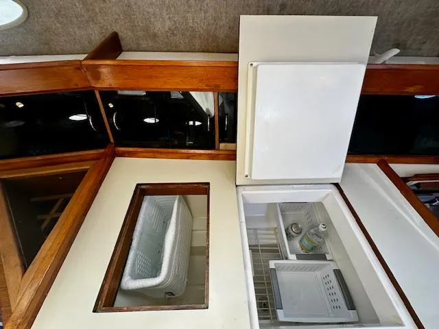 Slide: The Image of Interior view of 1986 Hunter Legend 45 yacht with open fridge and wooden accents. - 18