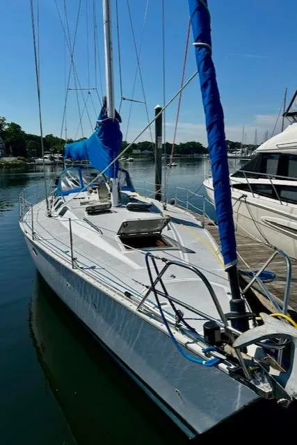 Slide: The Image of 1986 Hunter Legend 45 sailboat docked in a marina, featuring blue sail covers. - 2