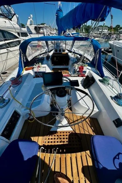 Slide: The Image of 1986 Hunter Legend 45 sailboat cockpit with steering wheel, wooden deck, and blue canopy. - 22