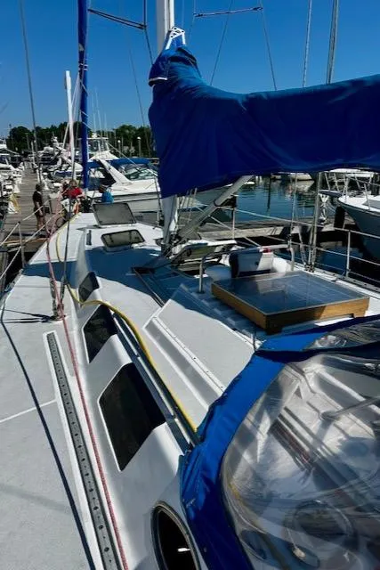 Slide: The Image of 1986 Hunter Legend 45 sailboat docked at marina, featuring blue sail cover and sleek design. - 24