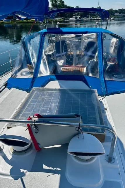 Slide: The Image of 1986 Hunter Legend 45 sailboat with blue canopy and solar panel on deck. - 29