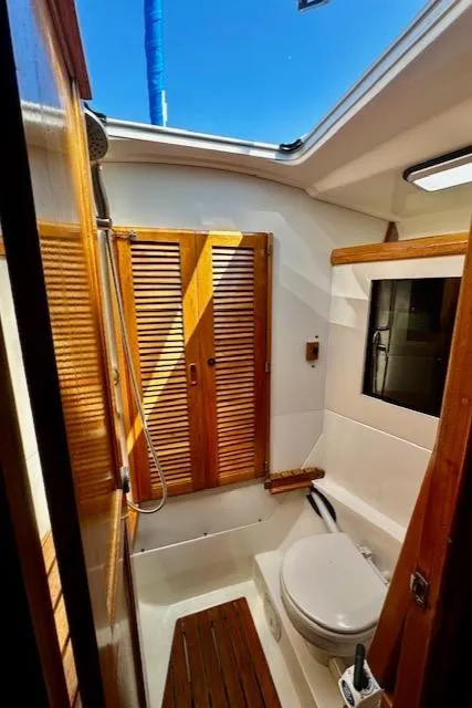Slide: The Image of 1986 Hunter Legend 45 yacht bathroom with wooden accents and skylight. - 34
