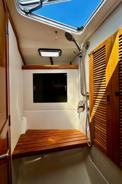Slide: The Image of Interior of 1986 Hunter Legend 45 yacht shower with wooden bench and skylight. - 35
