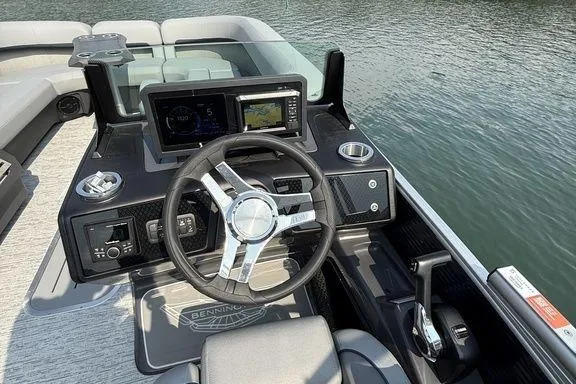 Slide: The Image of Steering console of 2026 Bennington M Quad Bench 24 MFB pontoon boat on water. - 14