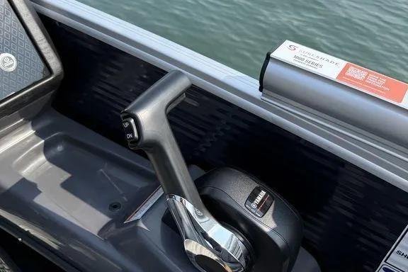 Slide: The Image of Control lever of 2026 Bennington M Quad Bench 24 MFB boat, near water. - 17