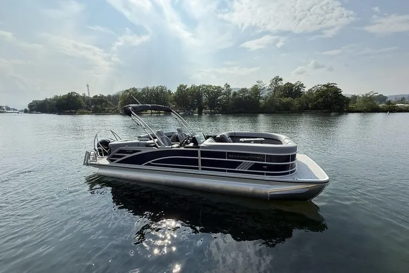 Slide: The Image of 2026 Bennington M Quad Bench 24 MFB pontoon boat on a serene lake. - 18