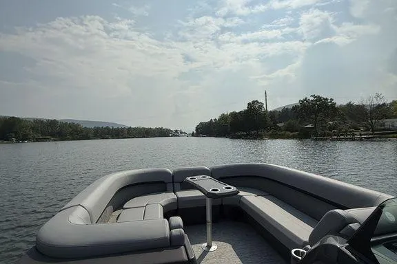 Slide: The Image of Bennington M Quad Bench 24 MFB 2026 pontoon boat on a serene lake under a cloudy sky. - 3