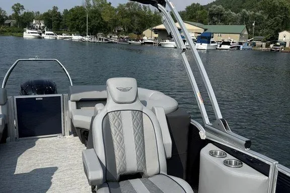 Slide: The Image of 2026 Bennington M Quad Bench 24 MFB pontoon boat on a scenic lake. - 5