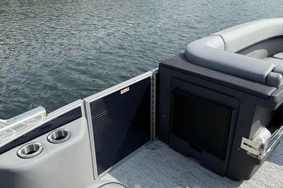 Slide: The Image of 2026 Bennington M Quad Bench 24 MFB boat interior with seating and cup holders on water. - 6