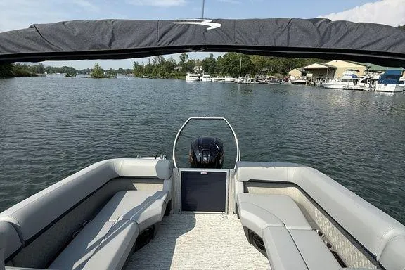 Slide: The Image of 2026 Bennington M Quad Bench 24 MFB pontoon boat on a scenic lake. - 9