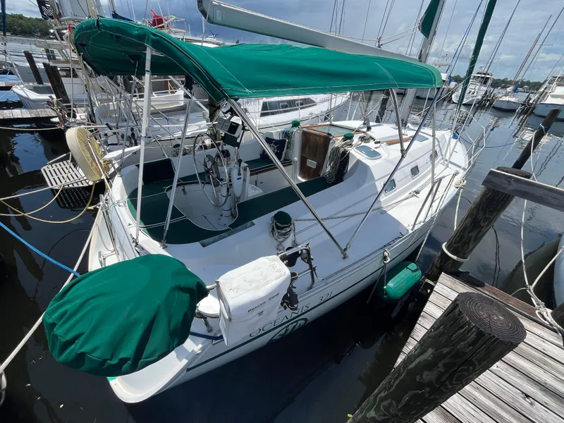 The Image of 1998 Beneteau 321 sailboat docked, featuring green canopy and clean deck. - 1