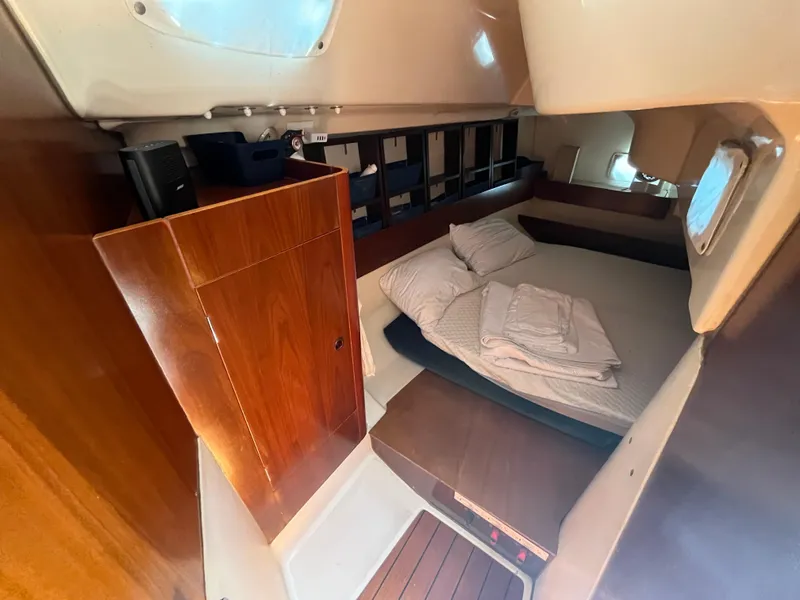 Slide: The Image of Cozy cabin interior of 1998 Beneteau 321 sailboat with bed and wooden storage. - 14