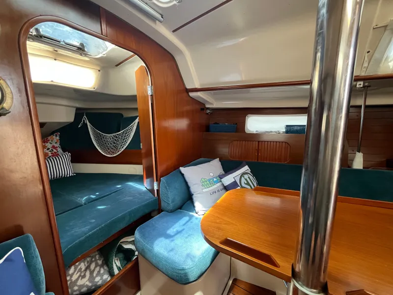 Slide: The Image of Cozy interior of 1998 Beneteau 321 sailboat with wooden finishes and blue seating. - 23