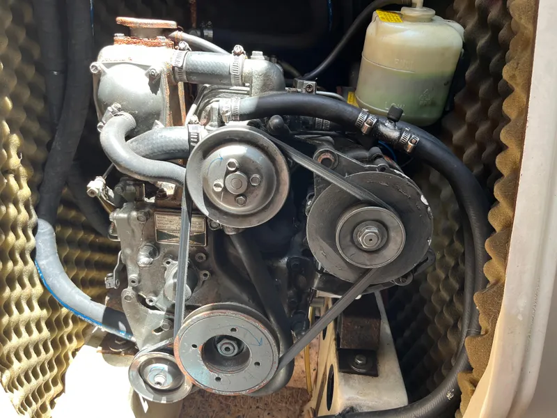 Slide: The Image of Engine compartment of a 1998 Beneteau 321 sailboat, showing belts and hoses. - 24