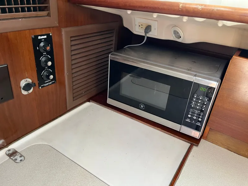 Slide: The Image of Microwave in 1998 Beneteau 321 yacht kitchen with control panel and wood finish. - 26