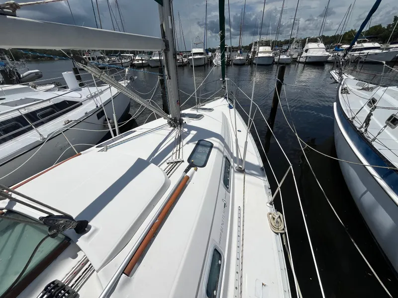Slide: The Image of Sailboat Beneteau 321, 1998 model, docked at marina with other boats under cloudy sky. - 29