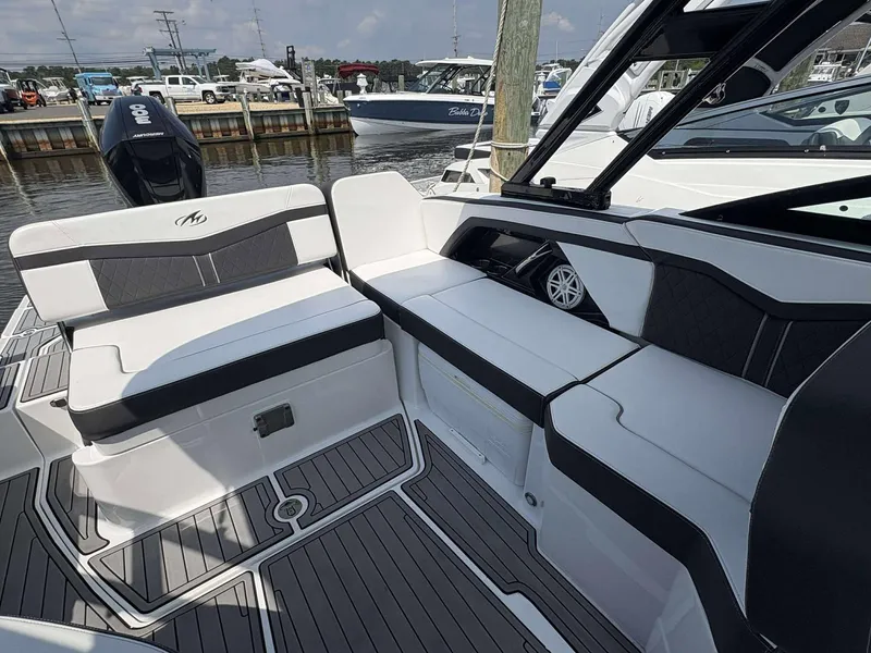 Slide: The Image of 2021 Monterey 255 Super Sport boat interior with sleek seating and modern design at a marina. - 12