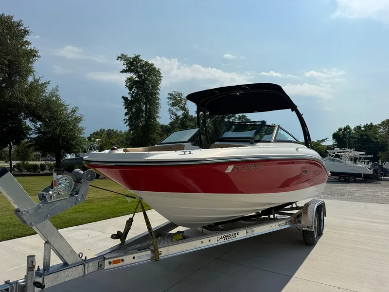 Slide: The Image of 2019 Sea Ray 21SPX boat on trailer, red and white, parked outdoors. - 1