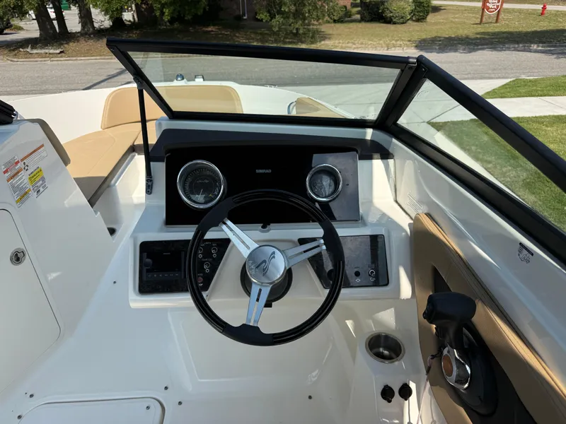 Slide: The Image of 2019 Sea Ray 21SPX boat dashboard with steering wheel and controls. - 22