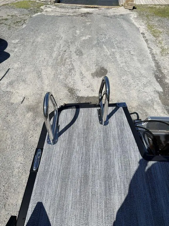 Slide: The Image of 2026 Bennington M Swingback 24 MSB pontoon boat on trailer by lakeside. - 2