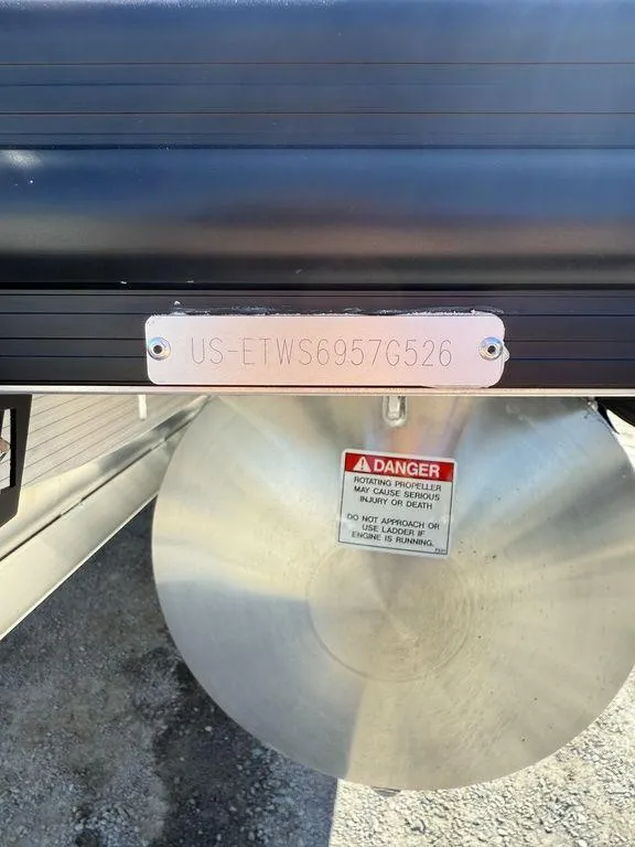 Slide: The Image of 2026 Bennington M Swingback 24 MSB boat with visible hull identification number and safety warning. - 4