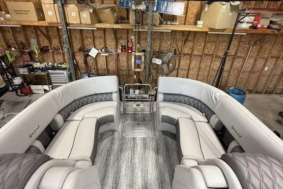 Slide: The Image of 2026 Bennington RX Sport Quad Bench 23 RXFB interior with luxurious seating in a garage setting. - 22