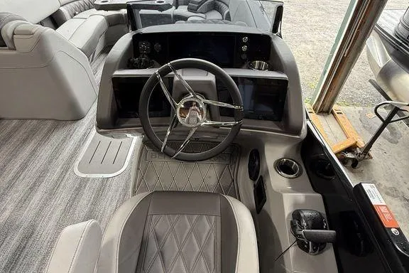 Slide: The Image of 2026 Bennington RX Sport Quad Bench 23 RXFB boat interior with steering wheel and seating. - 23