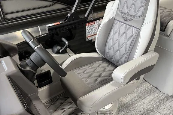 Slide: The Image of 2026 Bennington RX Sport Quad Bench 23 RXFB interior with luxurious captain's chair and steering console. - 24