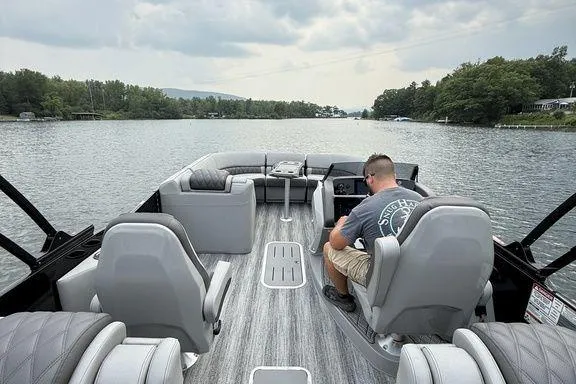 Slide: The Image of 2026 Bennington RX Sport Quad Bench 23 RXFB on a serene lake with a passenger. - 8
