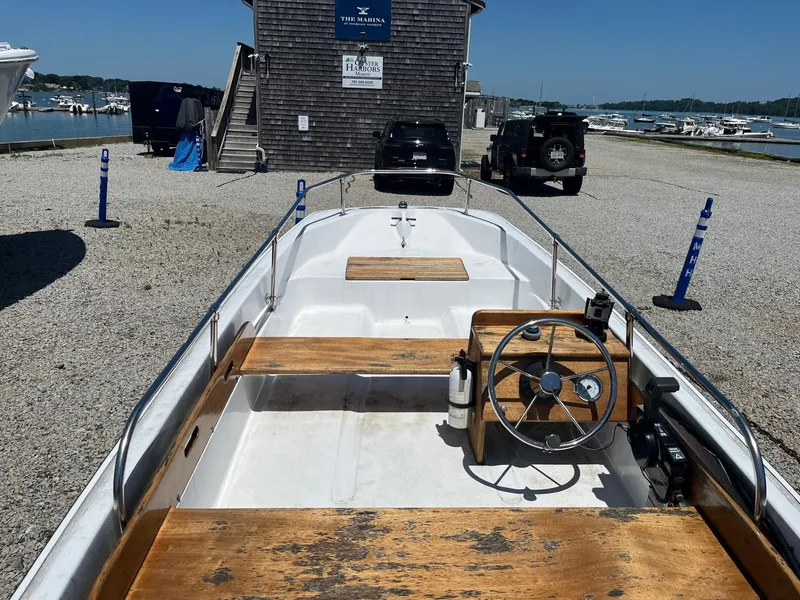 Slide: The Image of 1991 Boston Whaler 13 boat at marina, featuring wooden seats and steering wheel. - 3