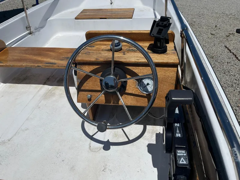 Slide: The Image of 1991 Boston Whaler 13 boat steering wheel and dashboard with wooden accents. - 4