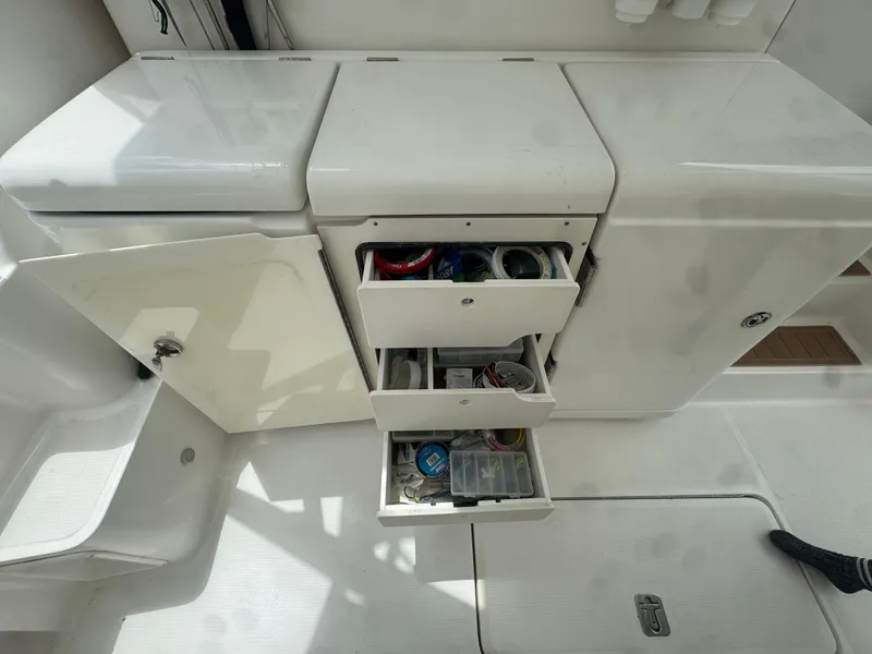Slide: The Image of Storage compartments on a 2006 Tiara Yachts 4200 Open, featuring open drawers and organized supplies. - 11