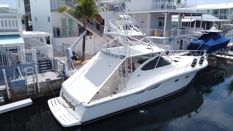 Slide: The Image of 2006 Tiara Yachts 4200 Open docked near waterfront homes. - 3