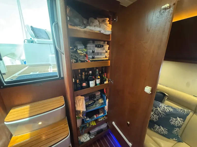 Slide: The Image of 2006 Tiara Yachts 4200 Open interior with wooden storage shelves and nautical-themed decor. - 38