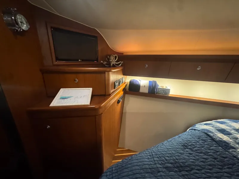 Slide: The Image of 2006 Tiara Yachts 4200 Open cabin interior with wood cabinetry and cozy bedding. - 44