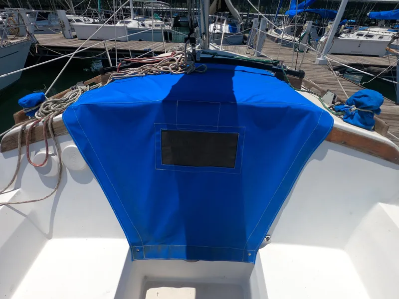Slide: The Image of 1985 Catalina 27 sailboat cockpit with blue cover, docked at marina. - 6