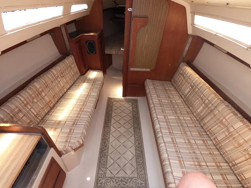 Slide: The Image of Interior of a 1985 Catalina 27 sailboat with plaid seating and wood paneling. - 8