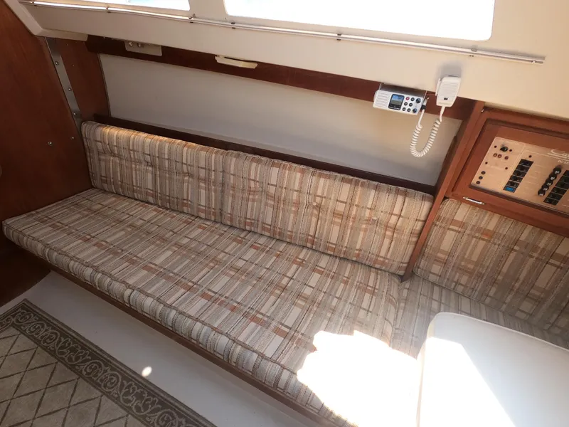 Slide: The Image of Interior of 1985 Catalina 27 sailboat with plaid seating and control panel. - 9