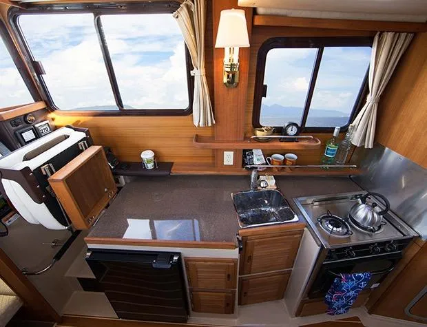 Slide: The Image of Manufacturer Provided Image: 2017 Ranger Tugs R-27 boat interior kitchen with stove, sink, and countertop. - 21
