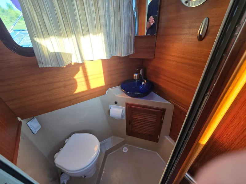 Slide: The Image of 2017 Ranger Tugs R-27 boat bathroom with wooden paneling and modern fixtures. - 24