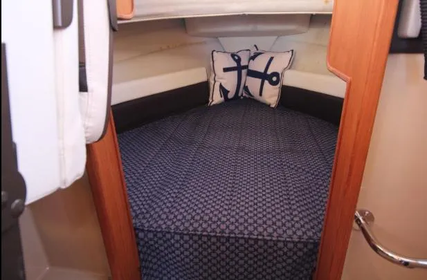 Slide: The Image of 2017 Ranger Tugs R-27 cabin interior with nautical-themed bedding and anchor pillows. - 28